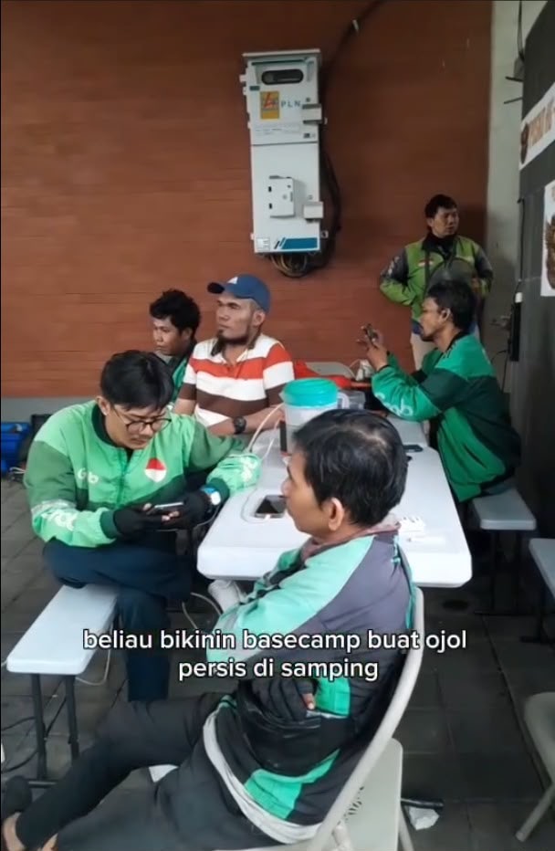 Pengemudi Gojek dan Grab duduk bersama di tempat singgah